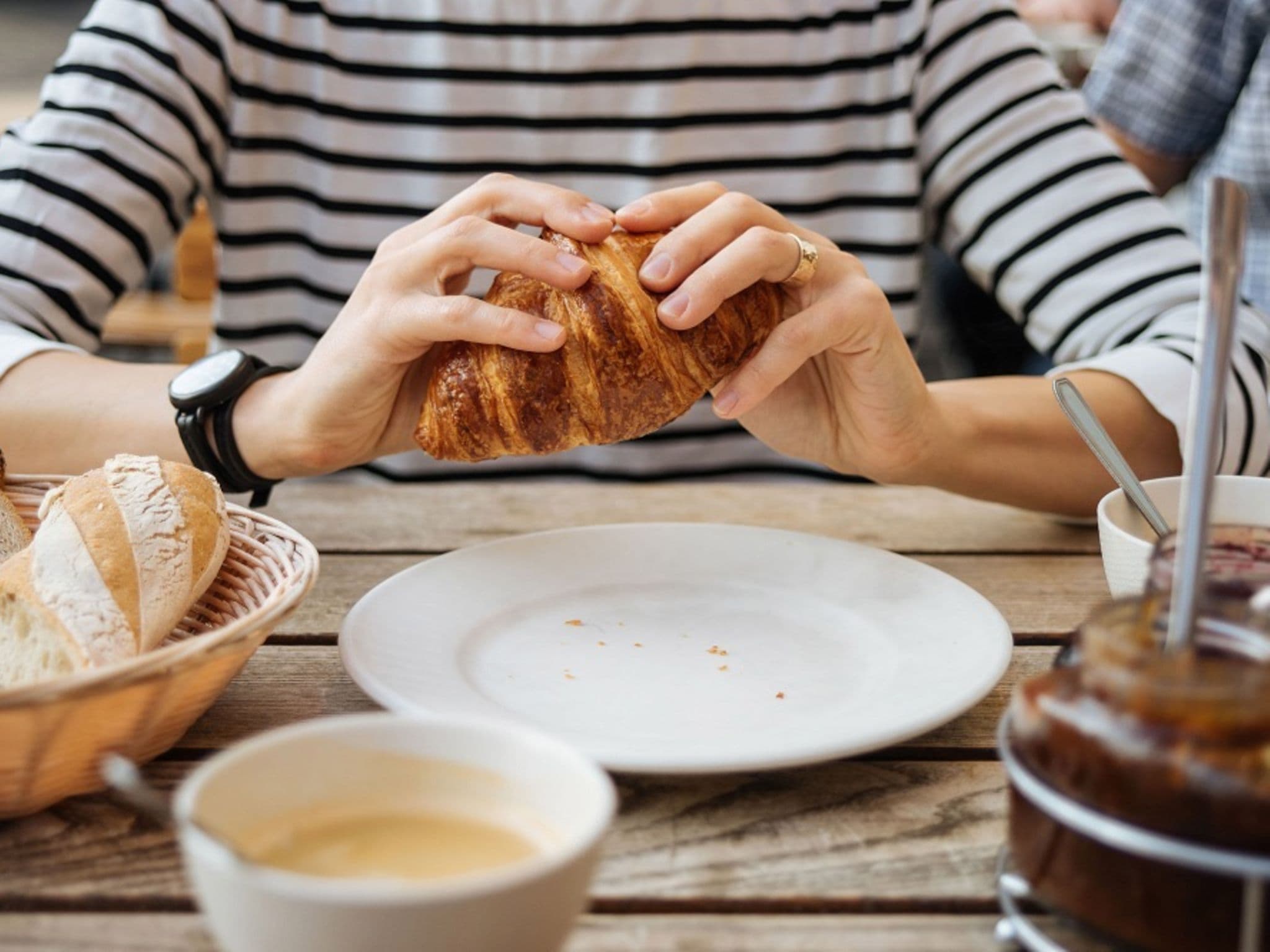 Diabetes mellitus Typ1: Frau hält ein Crossaint in den Händen.