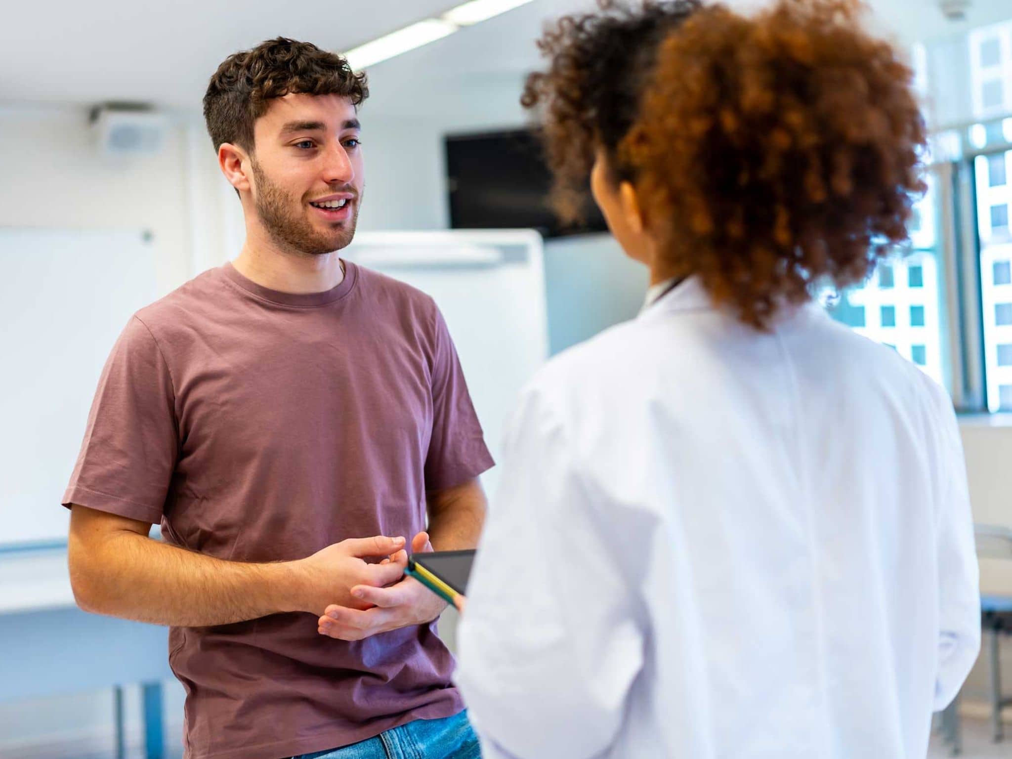 Junger Mann im Gespräch mit einer Fachärztin