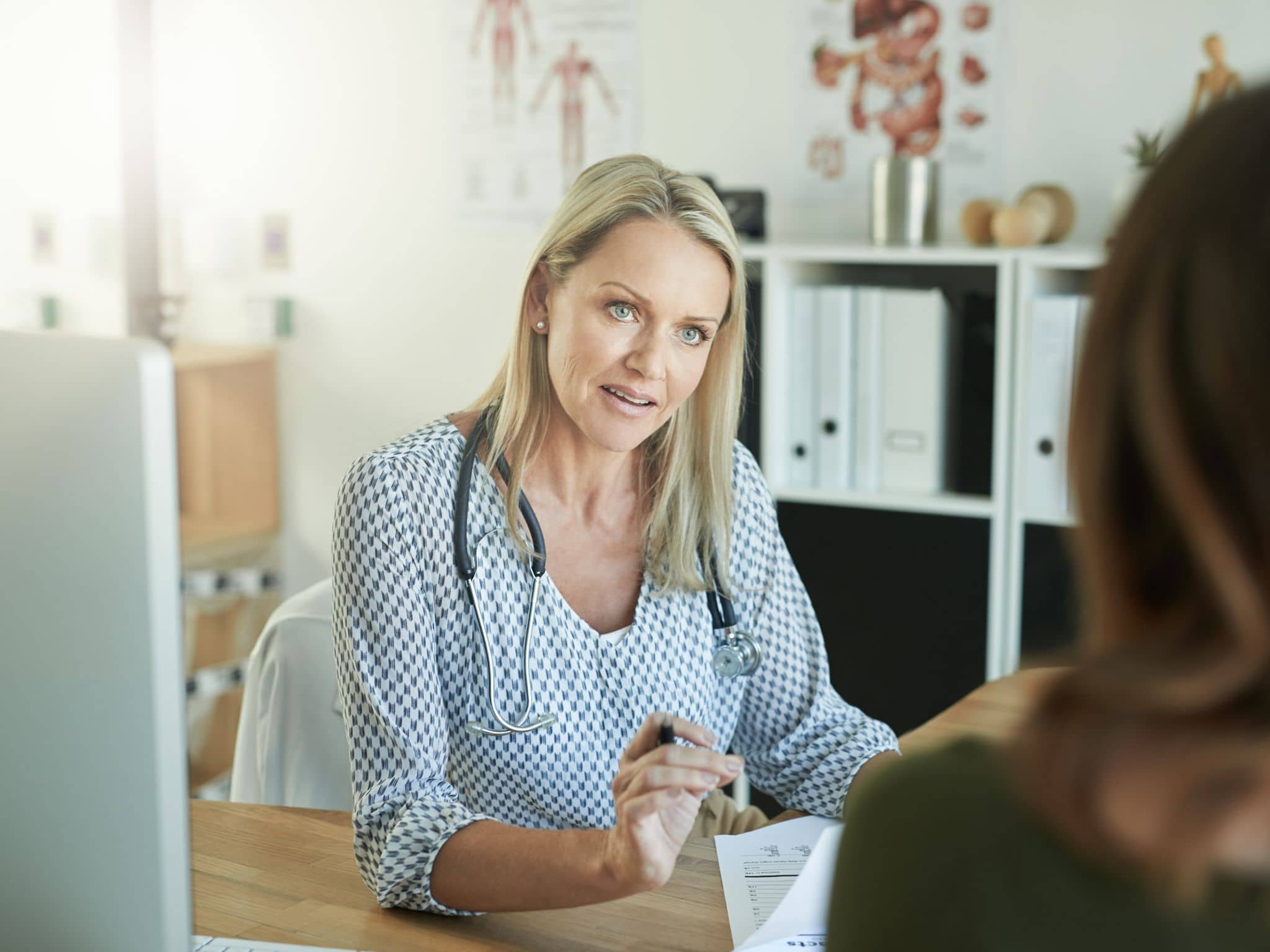 Hormonspirale: Eine Gynäkologin sitzt an ihrem Schreibtisch und berät eine Patientin
