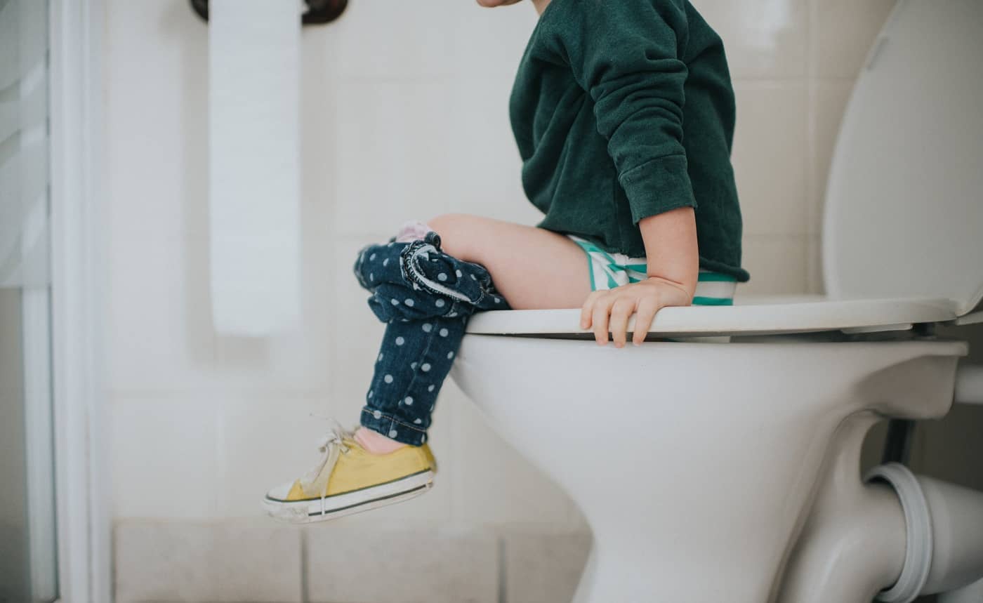 Ein Kind sitzt auf der Toilette.