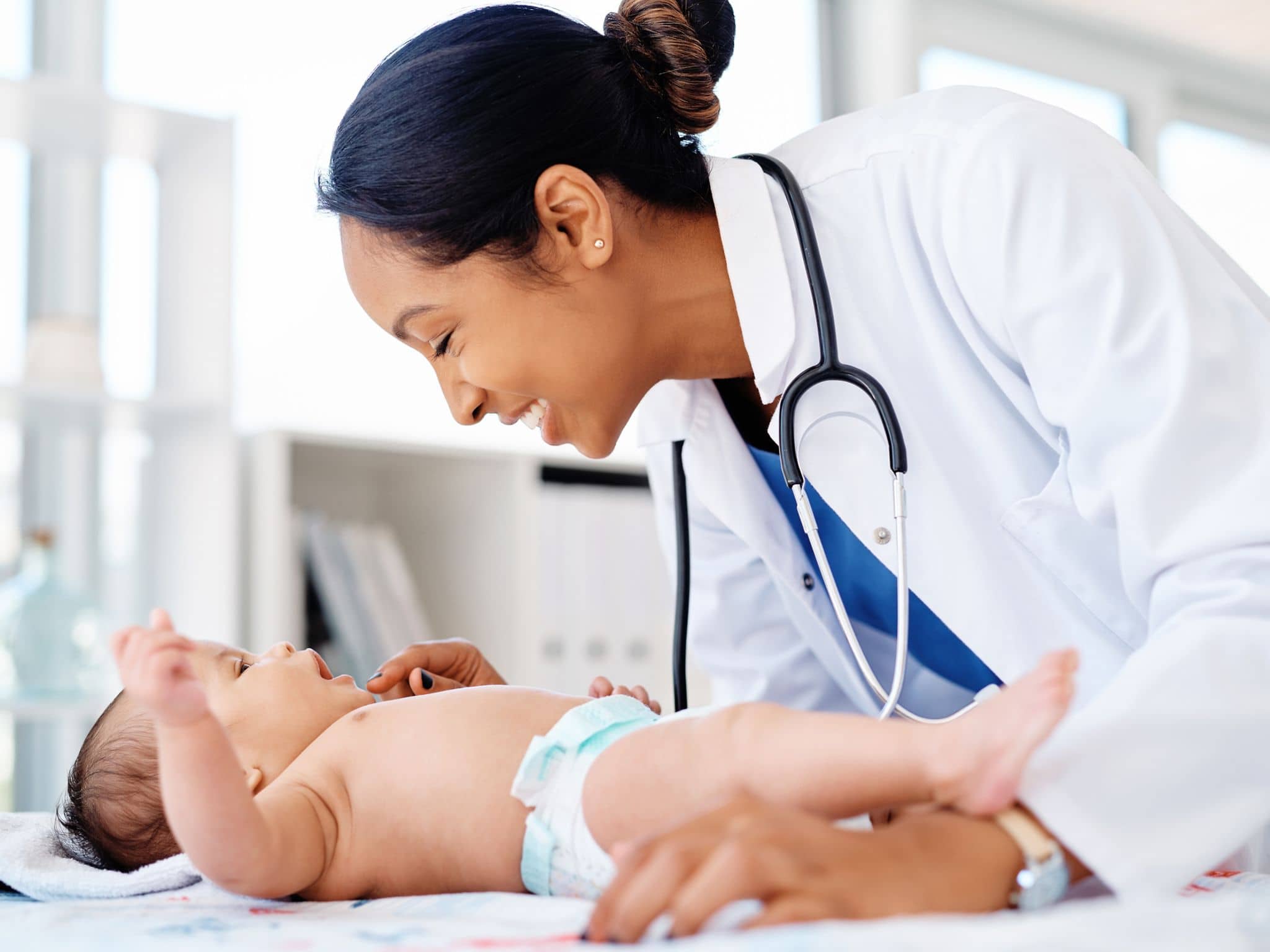 Ein Säugling wird von einer Ärztin untersucht.