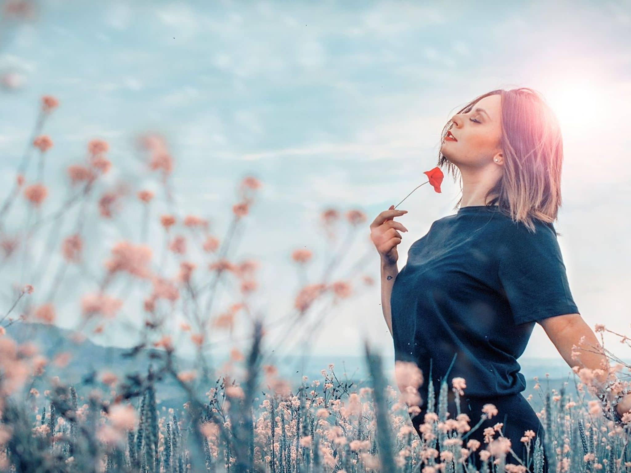 Sinnlichkeit: Eine Frau riecht an Blumen und genießt das Leben.