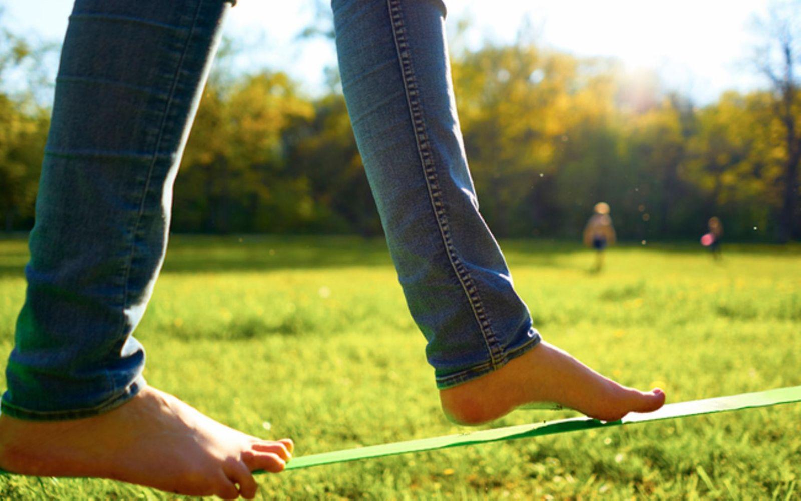 Outdoorspiele für Erwachsene: Ein Mensch balanciert auf der Slackline
