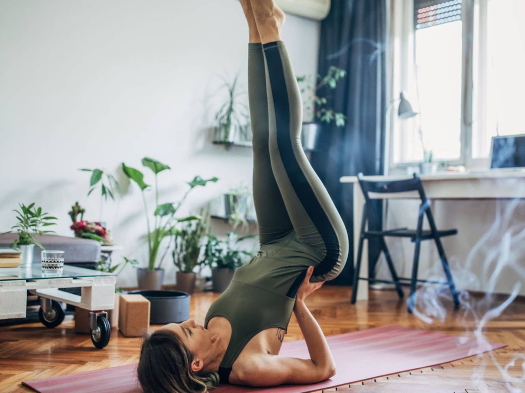 Bandscheibenvorfall: Frau macht Yoga-Übung auf der Matte, um einem Bandscheibenvorfall vorzubeugen