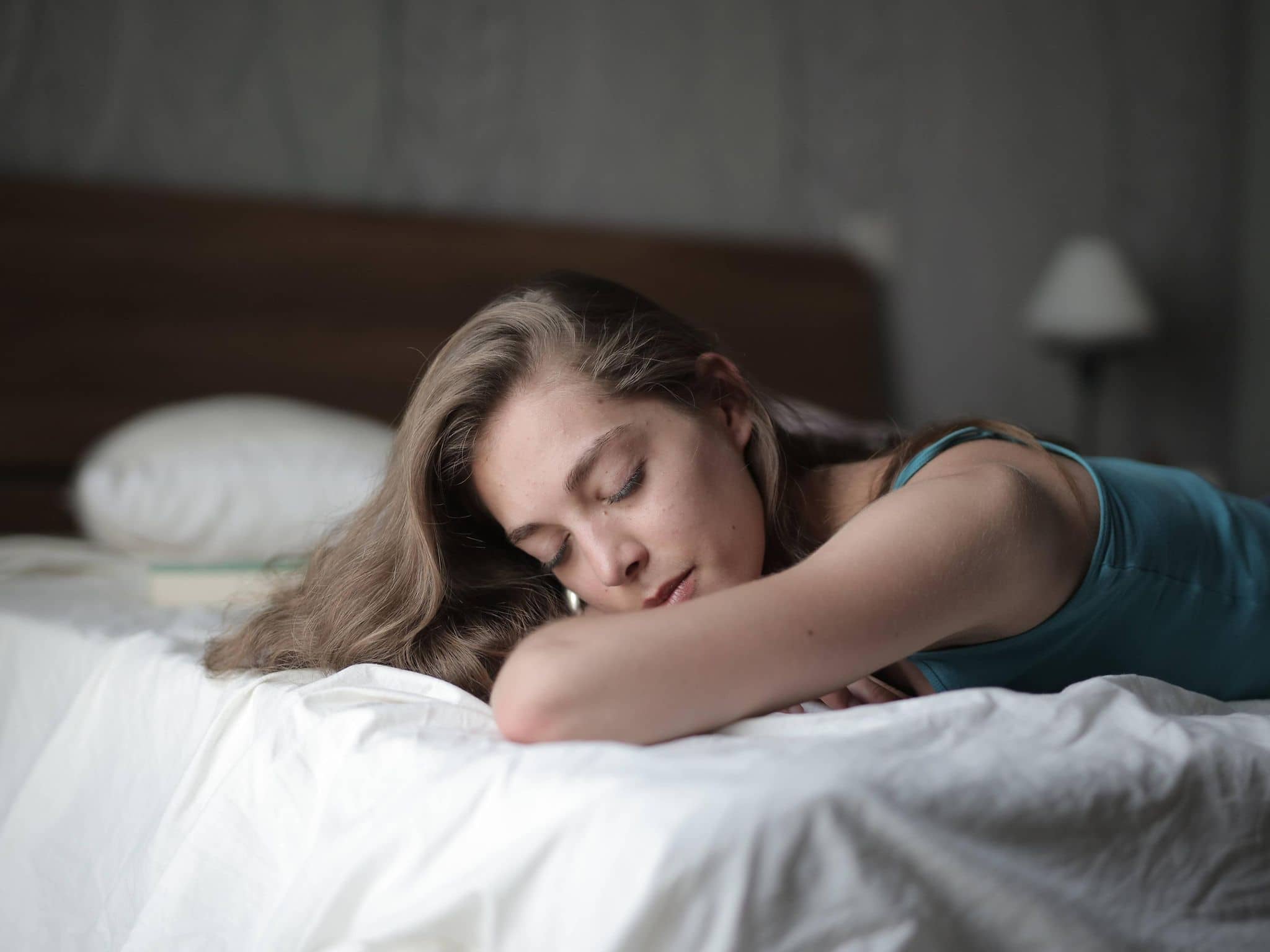 Junge Frau schläft friedlich im Bett.