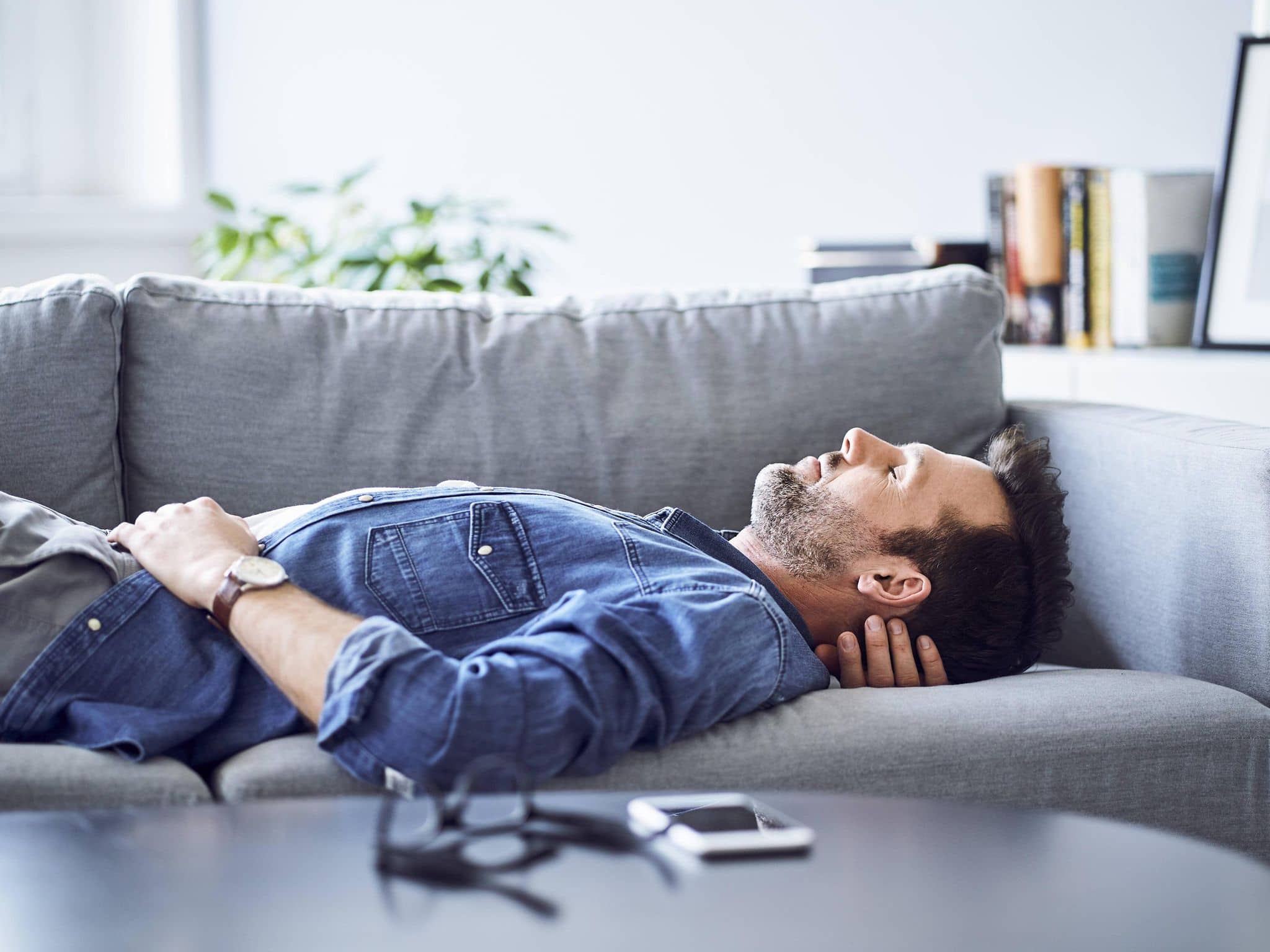 Mann ruht sich auf dem Sofa aus.