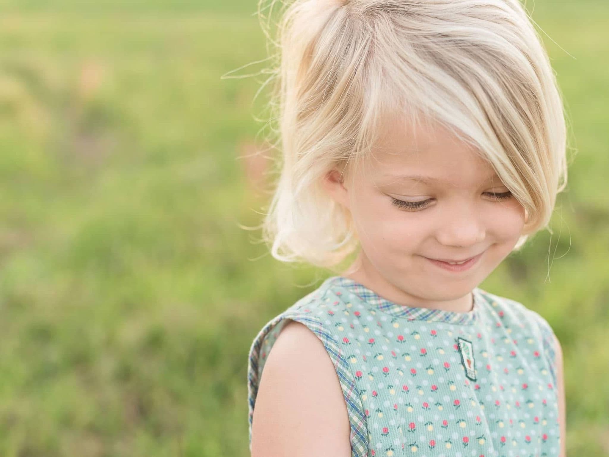 U7 Untersuchung: Kleines blondes Mädchen schaut schüchtern lächelnd auf den Boden.