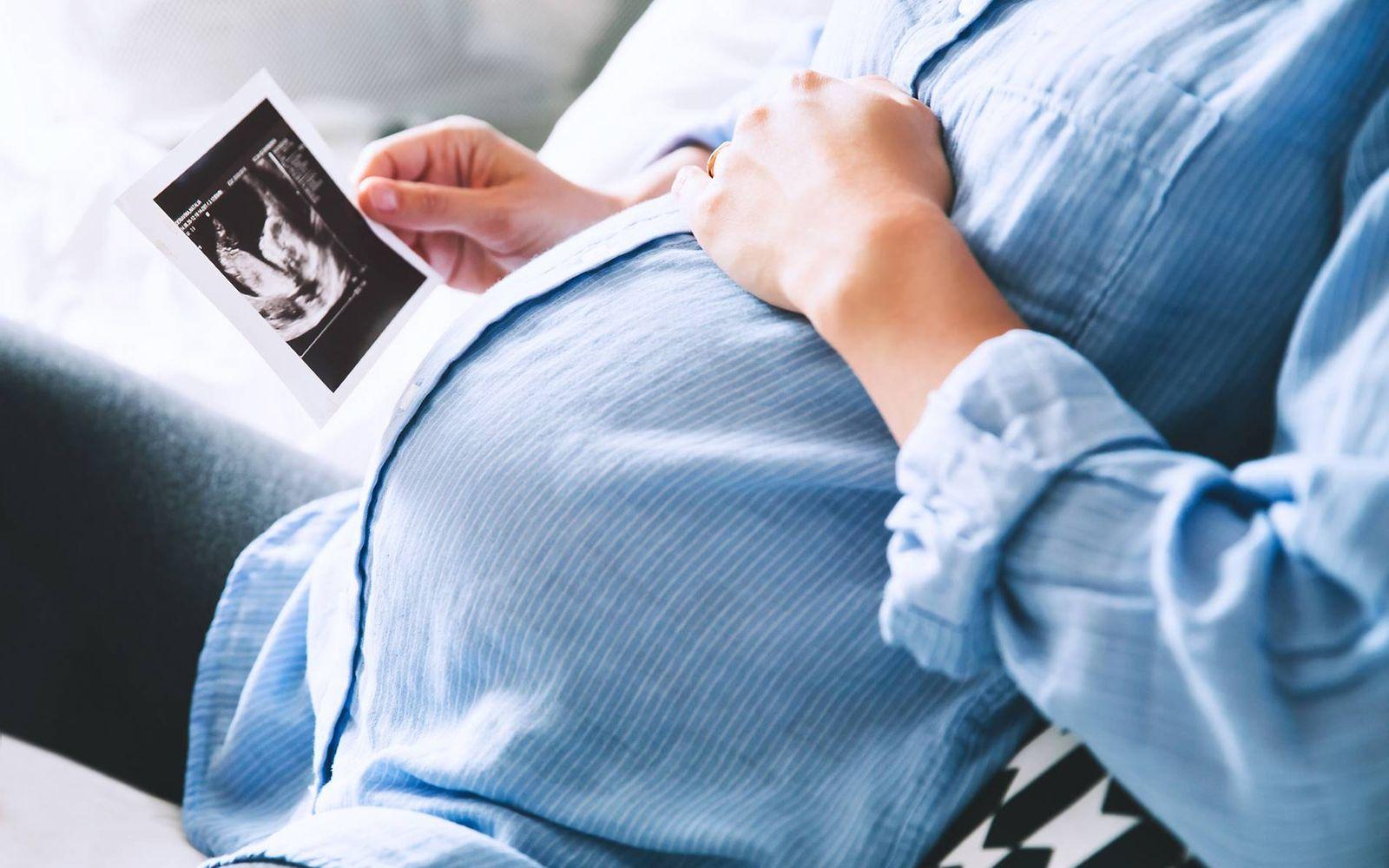Checkliste Schwangerschaft: Schwangere betrachtet Ultraschallbild
