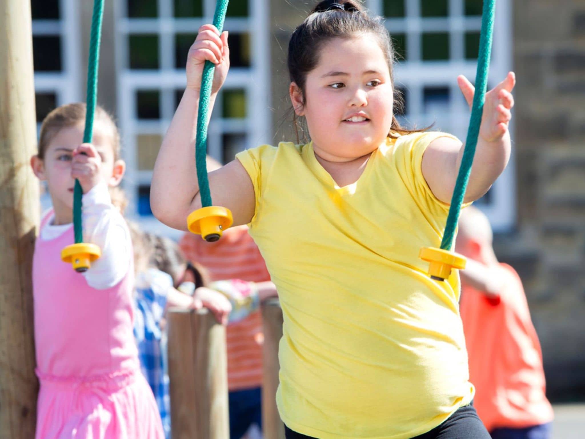 Übergewicht bei Kindern: Ein übergewichtiges Mädchen sitzt auf einer Schaukel