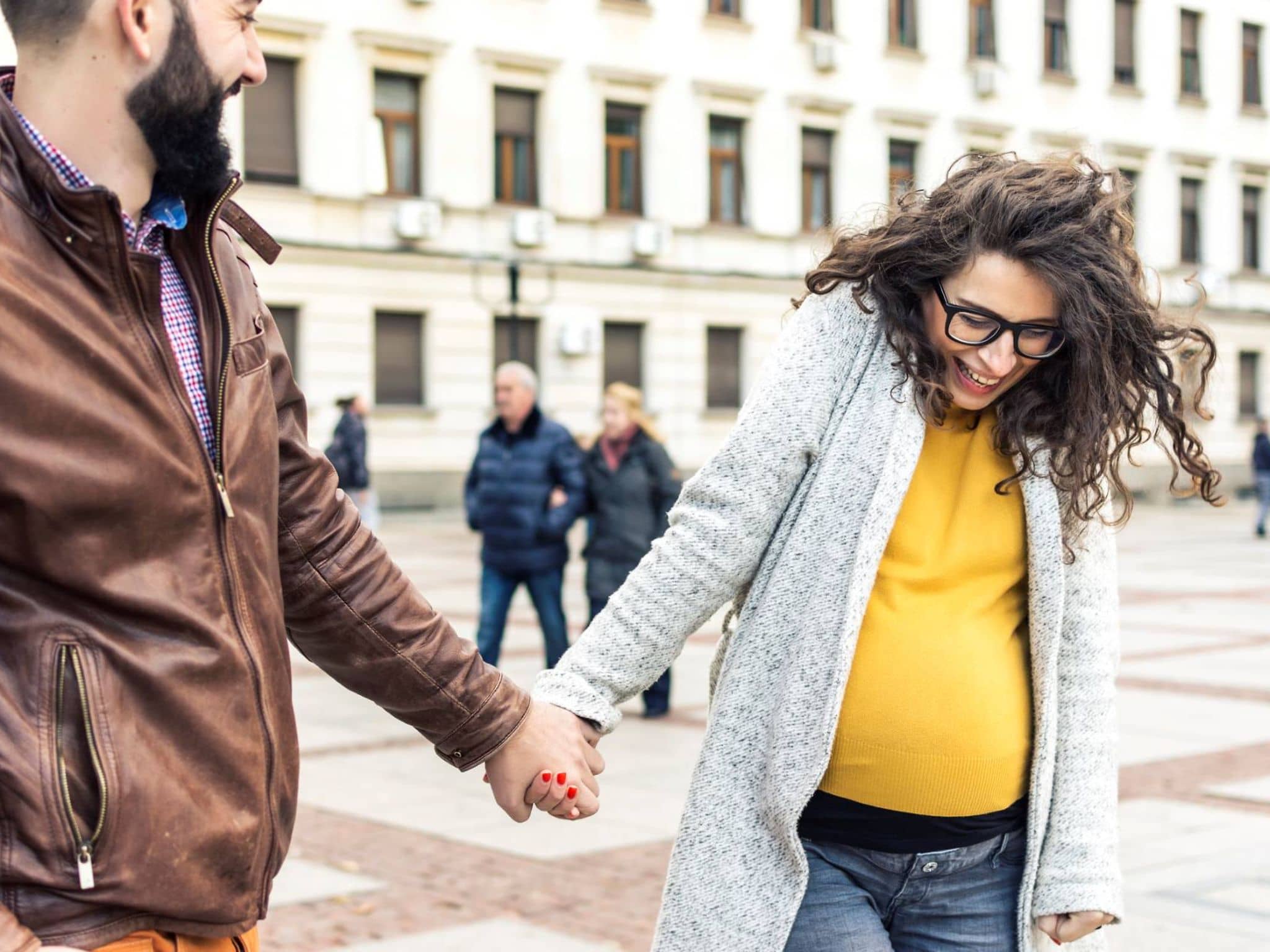 Symbolbild Geburtsvorbereitung: Paar spaziert händchenhaltend durch die Stadt