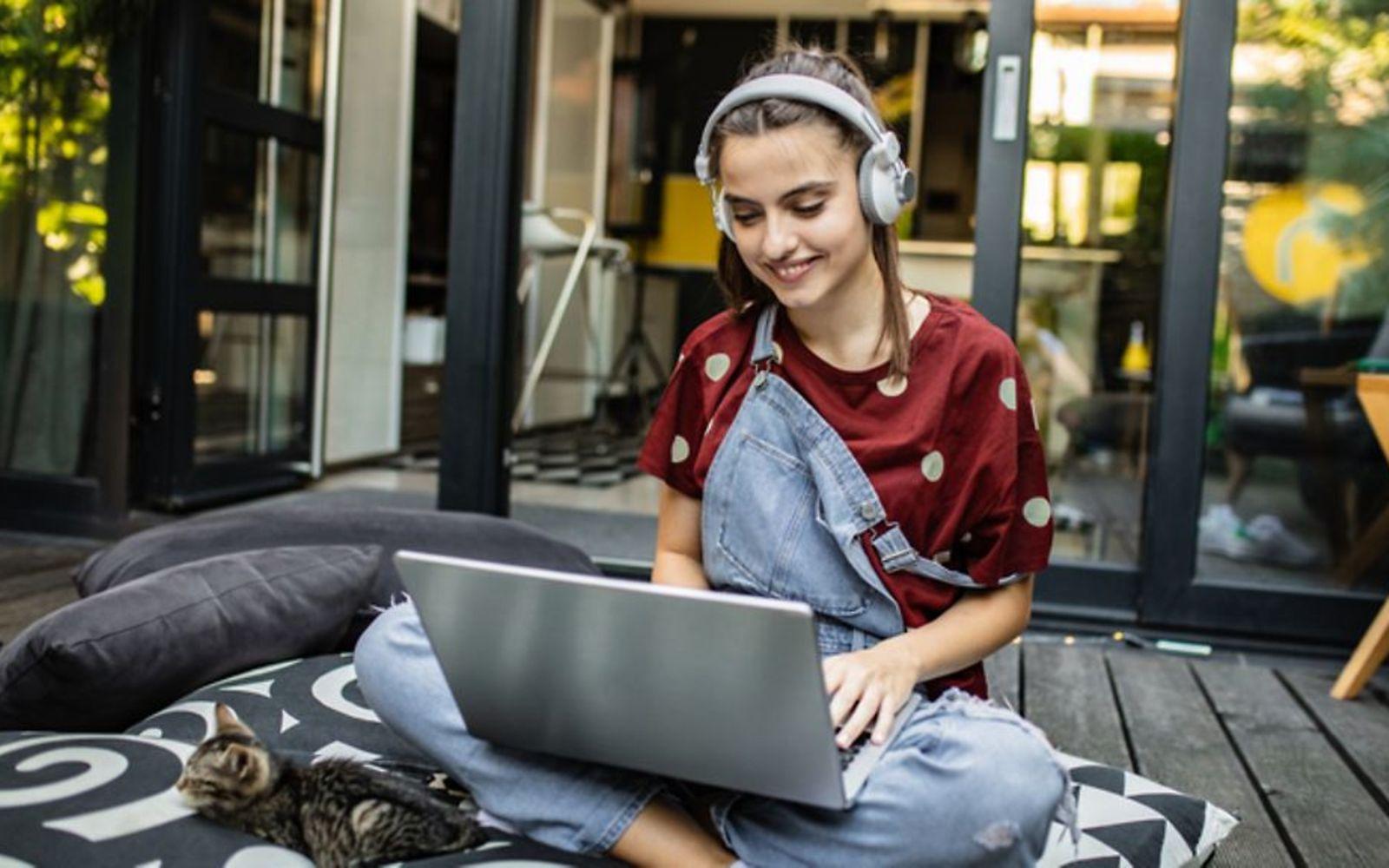 Symboldbild für Online-Shopping: Ein Teenager-Mädchen sitzt vorm Computer und shoppt online