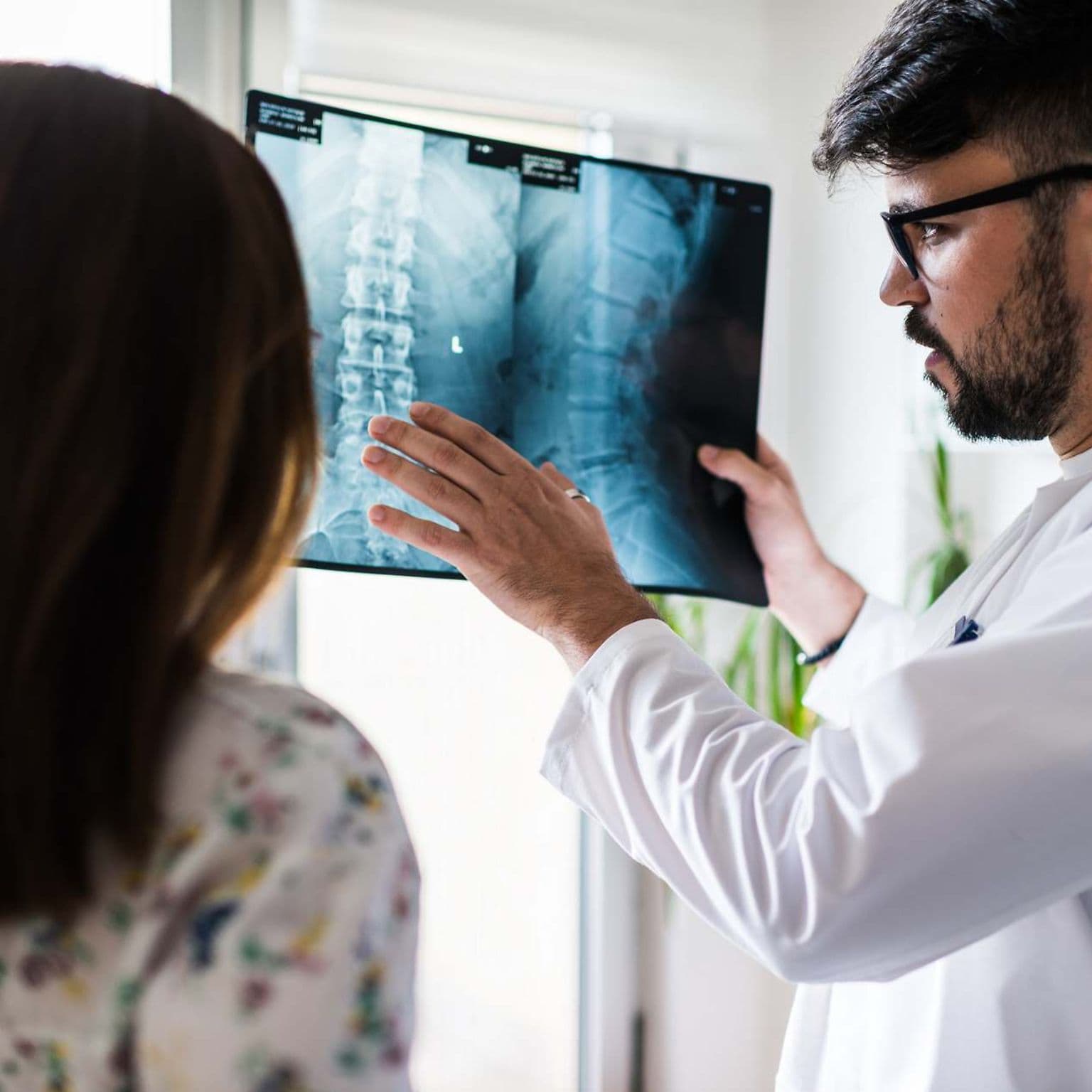 Bild: Arzt erklärt einer Patientin etwas zu ihrem Röntgenbild der Wirbelsäule.