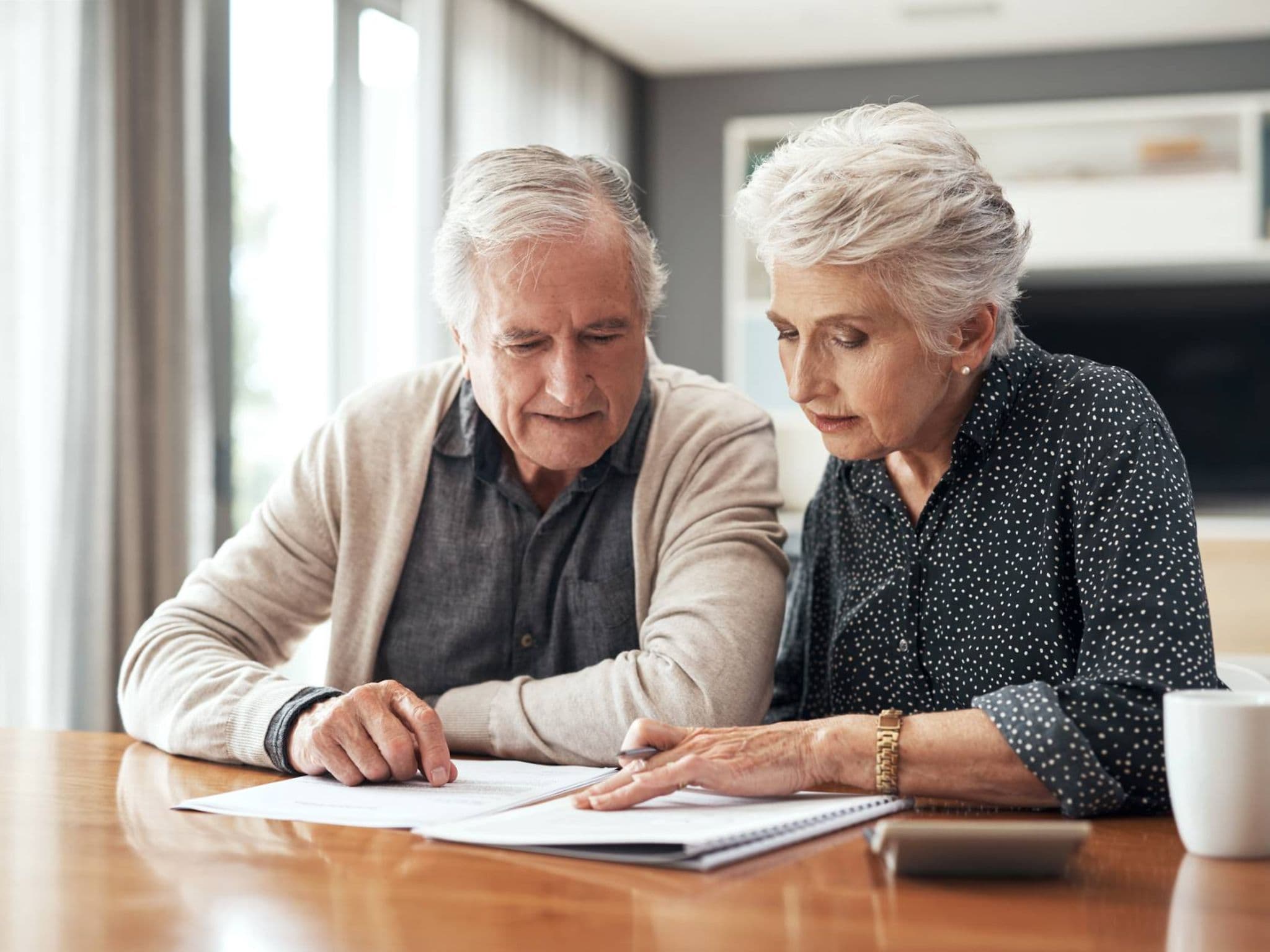 Pflegeanträge: Älteres Paar füllt Formulare aus