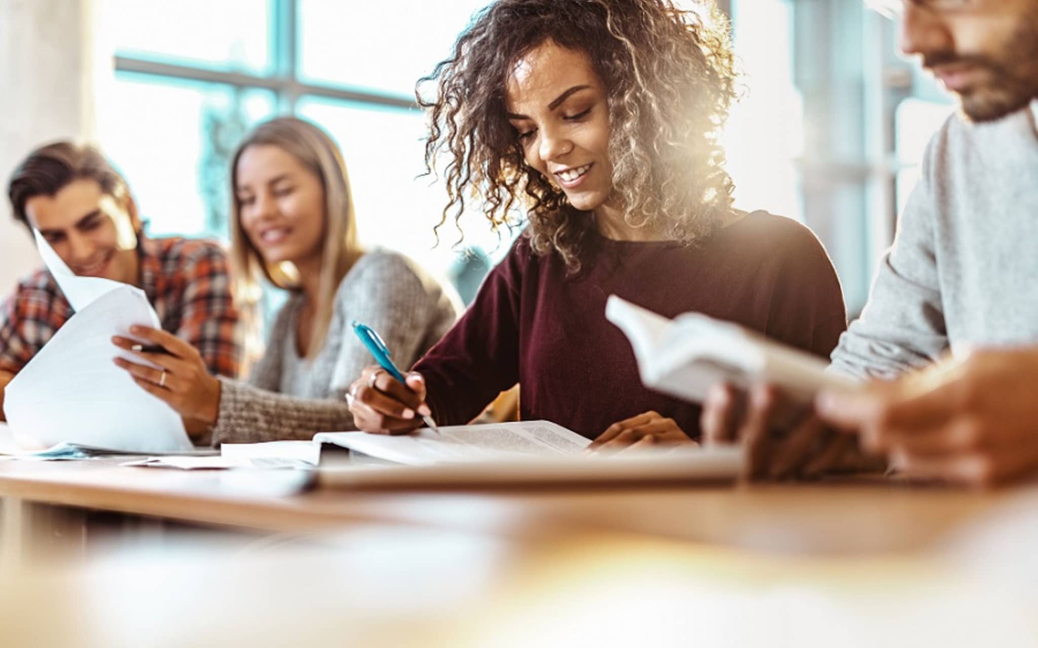 Junge Frau schreibt in ihr Heft.