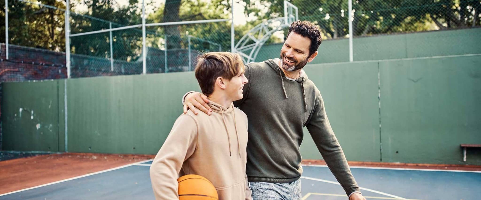 Vater und Sohn haben Basketball gespielt und freuen sich, dass der DAK AktivBonus einen aktiven Lebensstil belohnt.