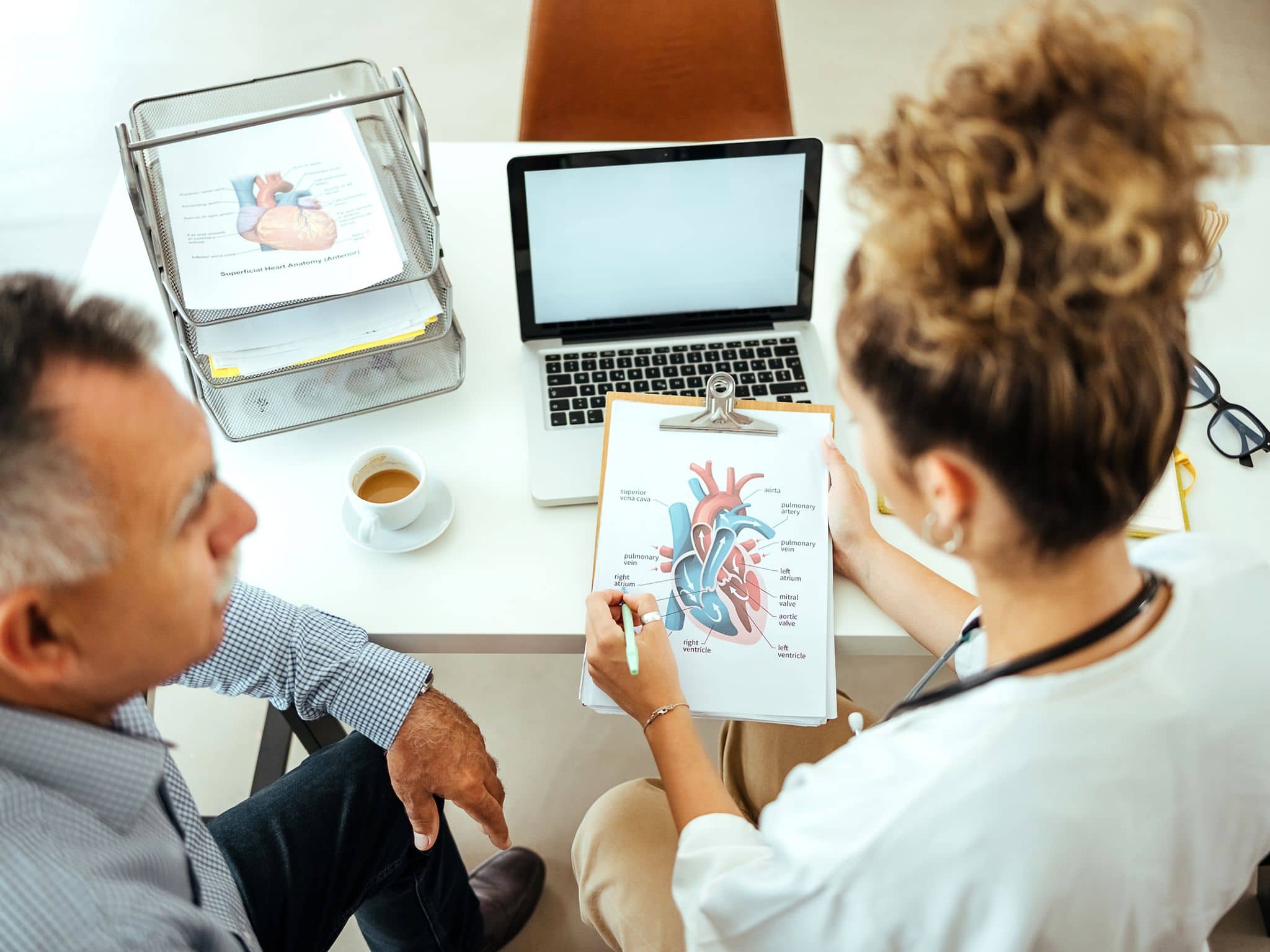 Zweitmeinung-Cardio: Ärztin berät männlichen Patienten zum Thema Herz-Operation