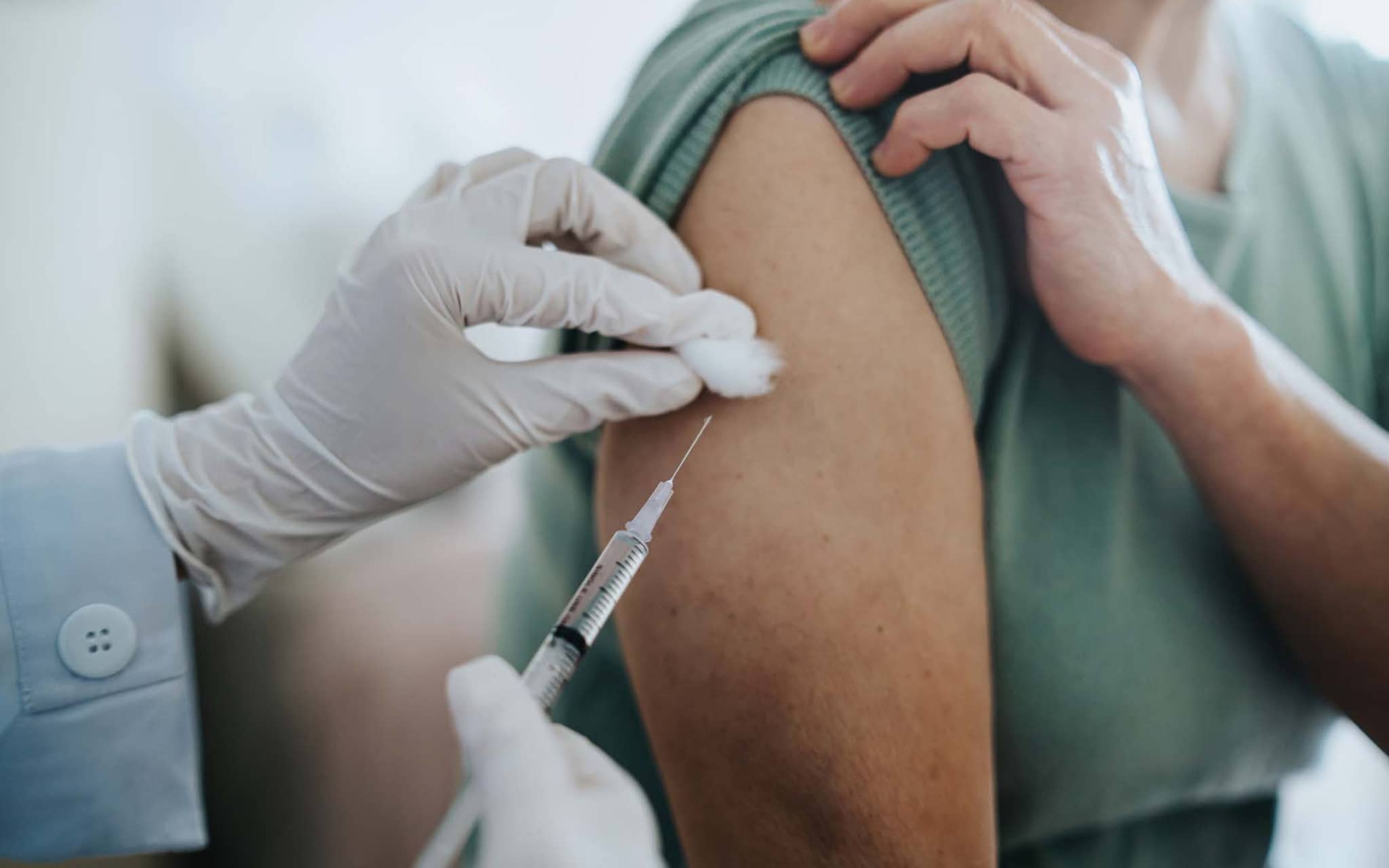 HPV-Impfung: Ärztin klebt einer Teenagerin nach der Impfung ein Pflaster auf den Arm.