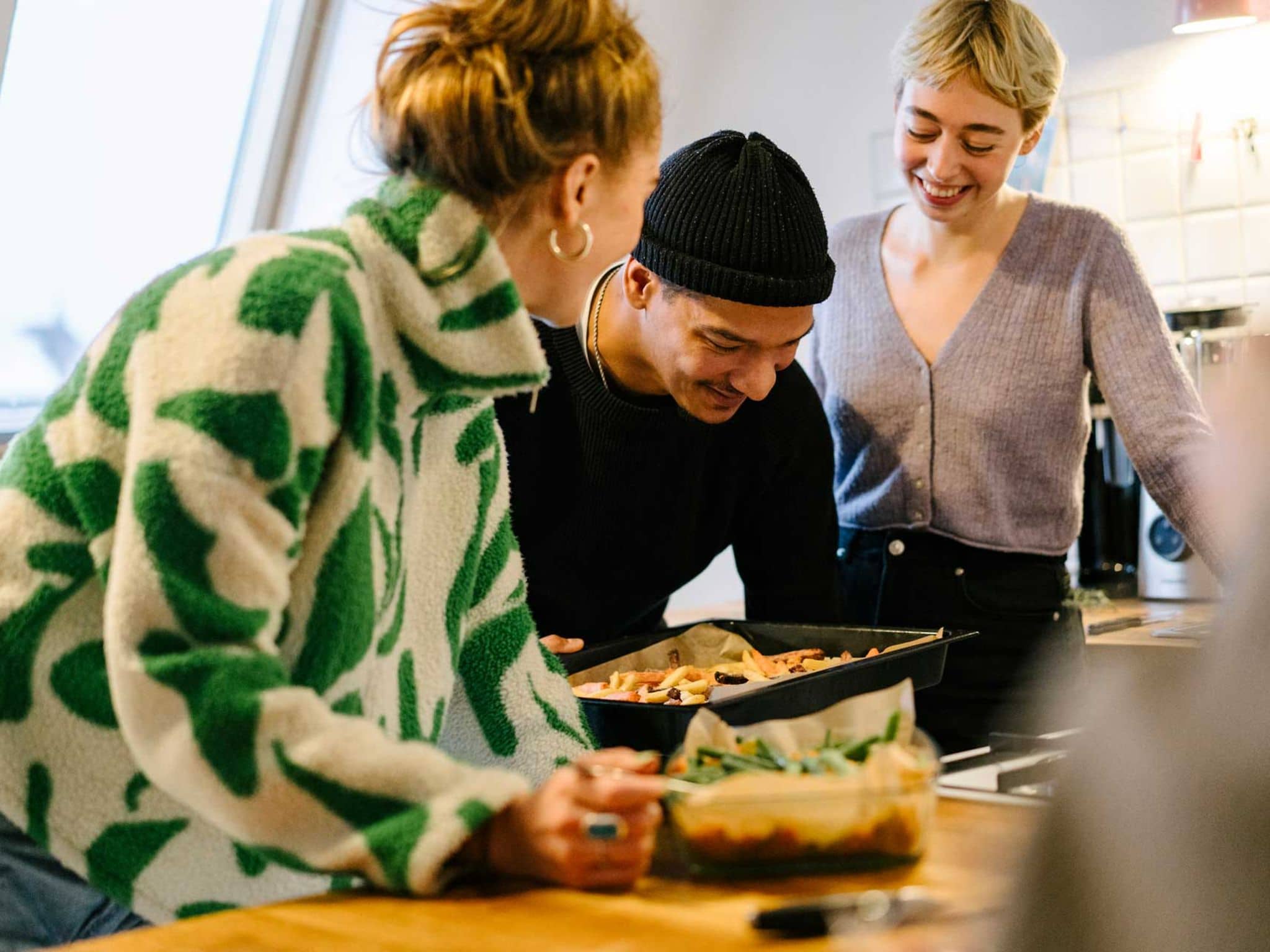 Symbolbild Krankenkassenwechsel: Freunde kochen gemeinsam
