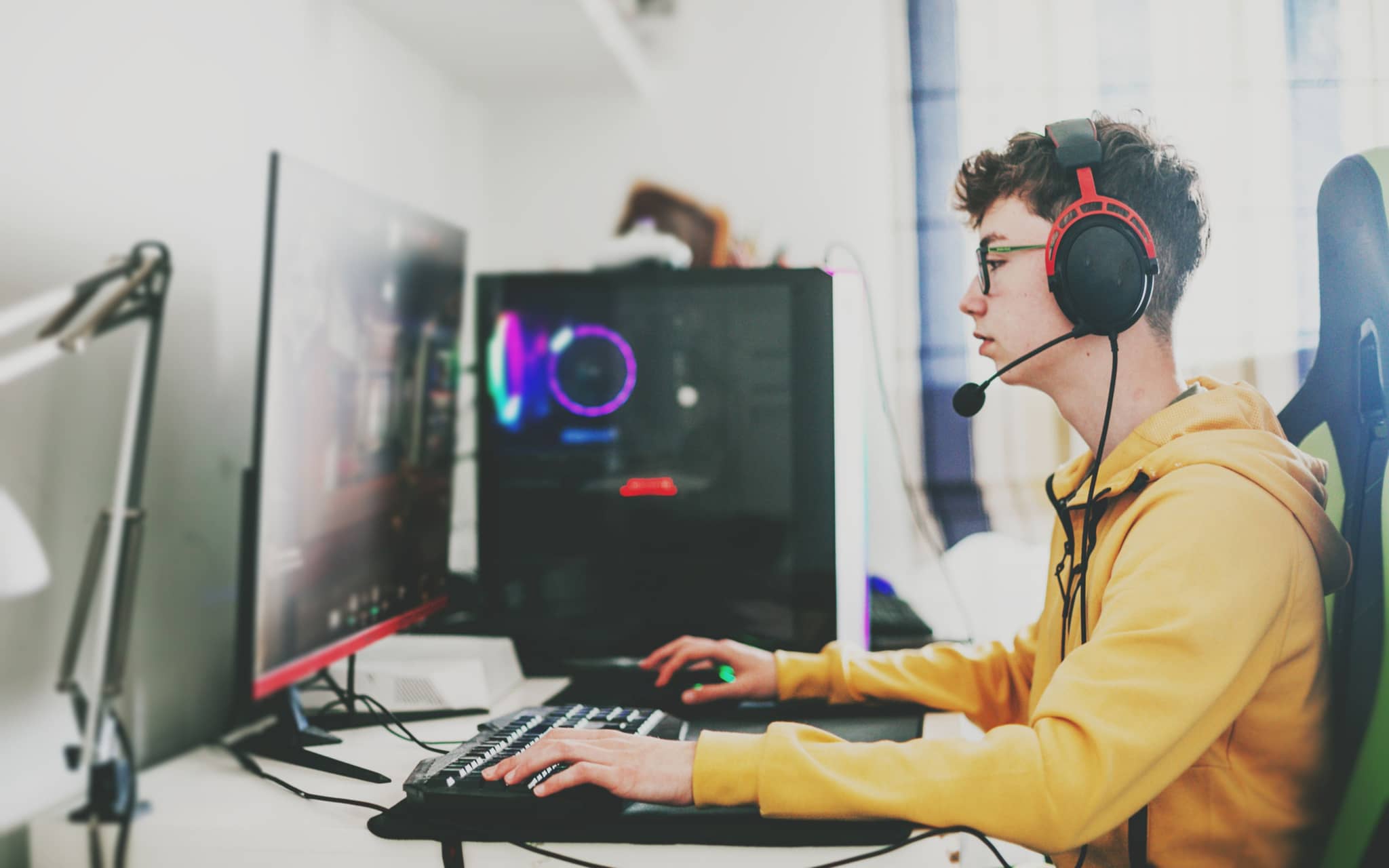 Bild: Teenager mit Headset spielt an einem Computer