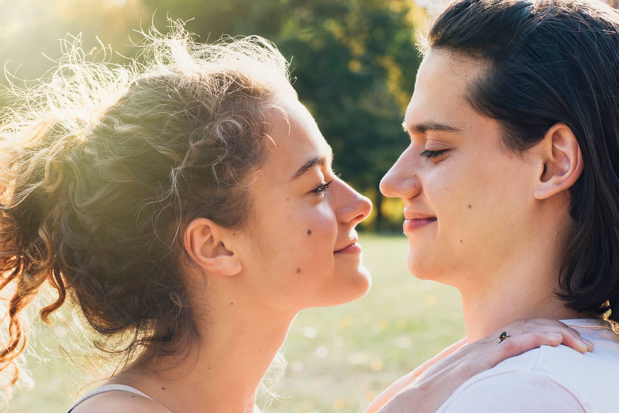 Muttermale: Zwei Frauen begutachten spielerisch ihre Muttermale im Gesicht inmitten von Natur