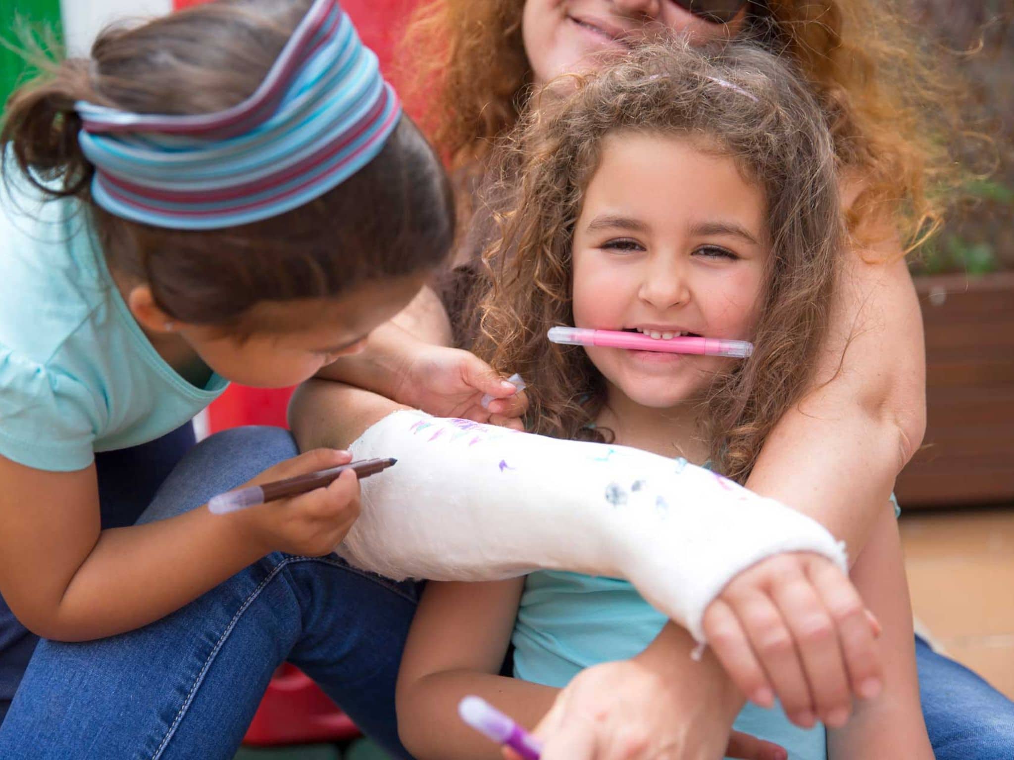 Symbolbild Sturzprophylaxe bei Osteoporose: Enkel bemalen Gipsarm