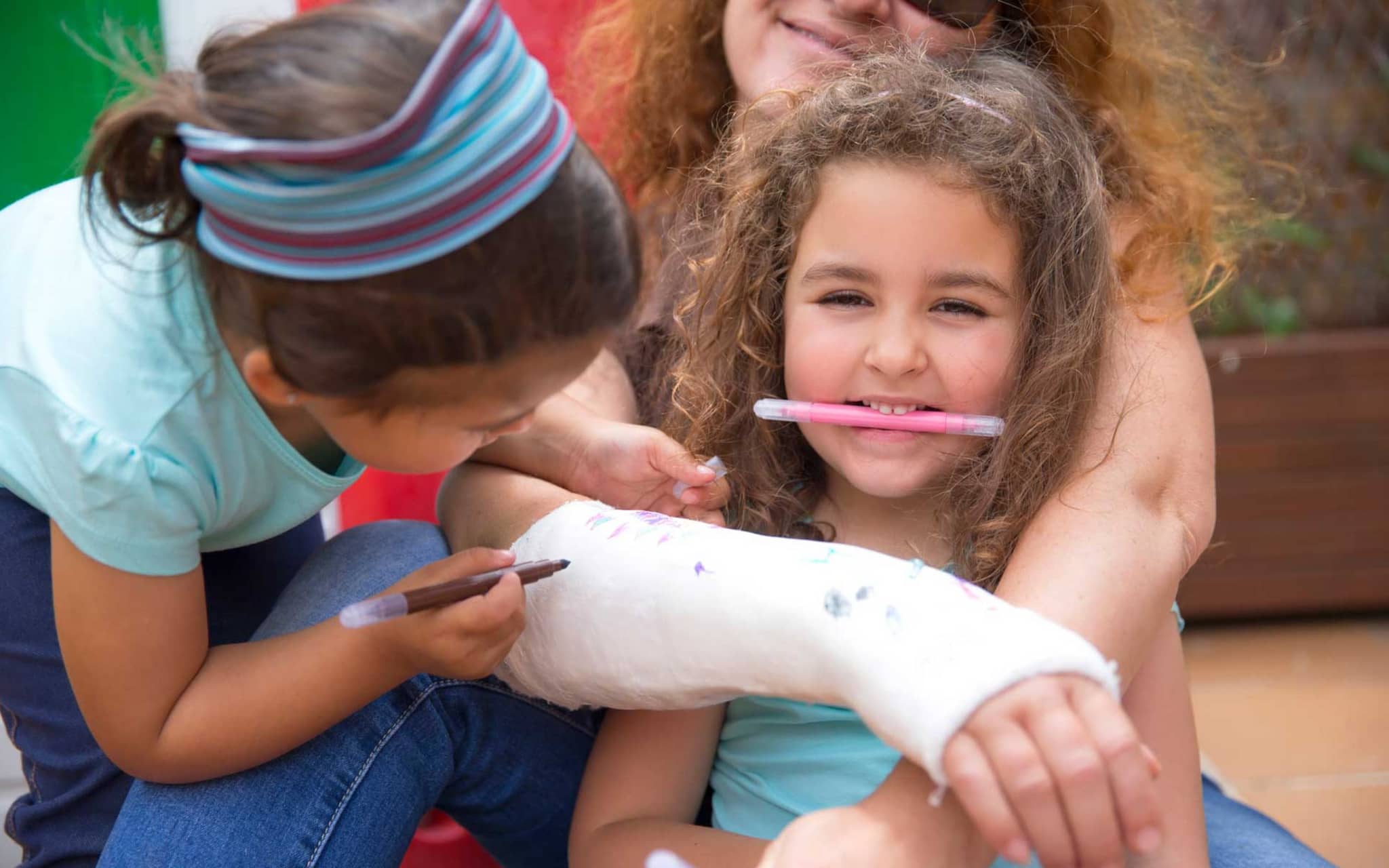 Symbolbild Sturzprophylaxe bei Osteoporose: Enkel bemalen Gipsarm