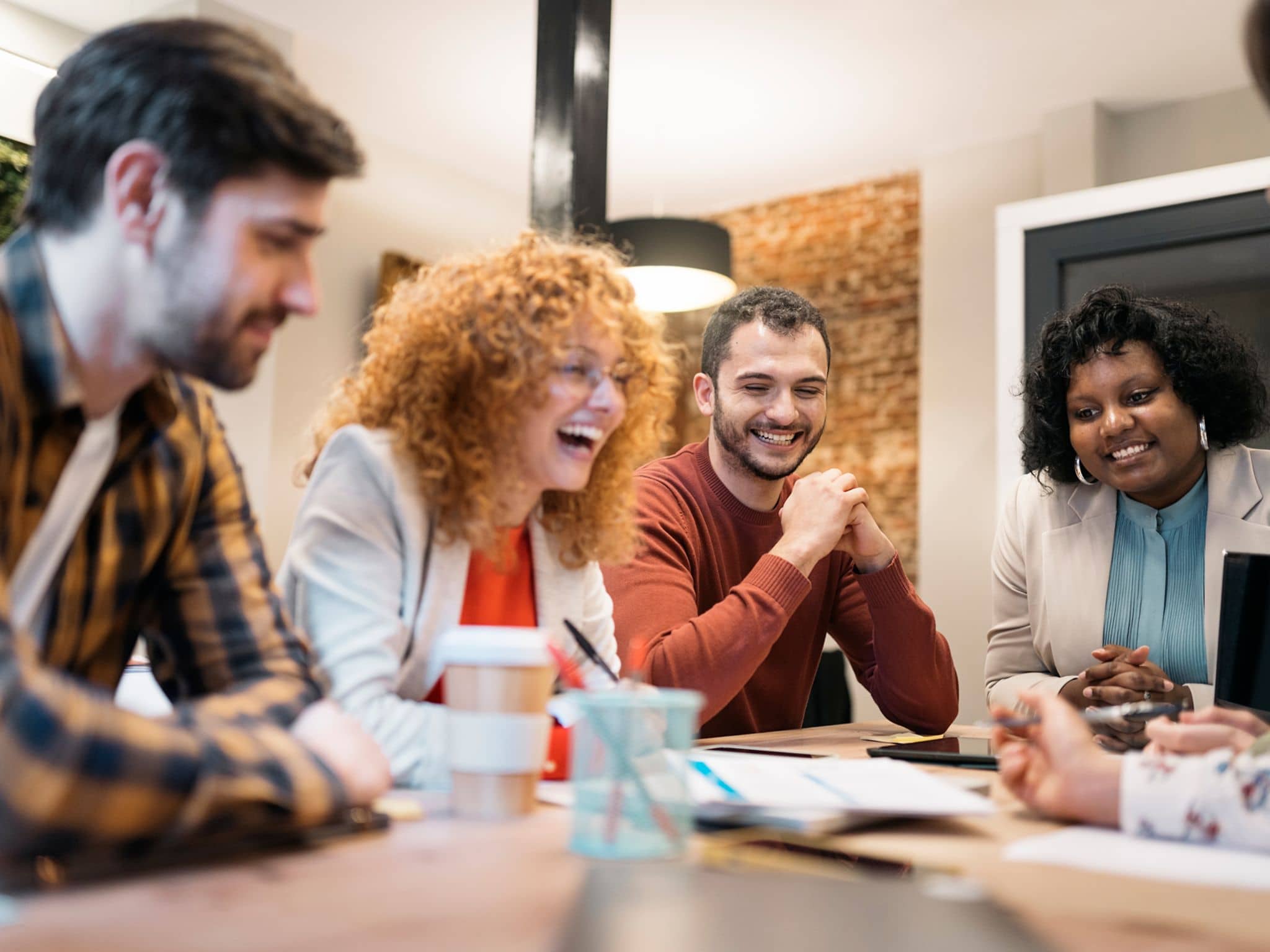 Slika: Grupa kolega na poslu u neobaveznom razgovoru.