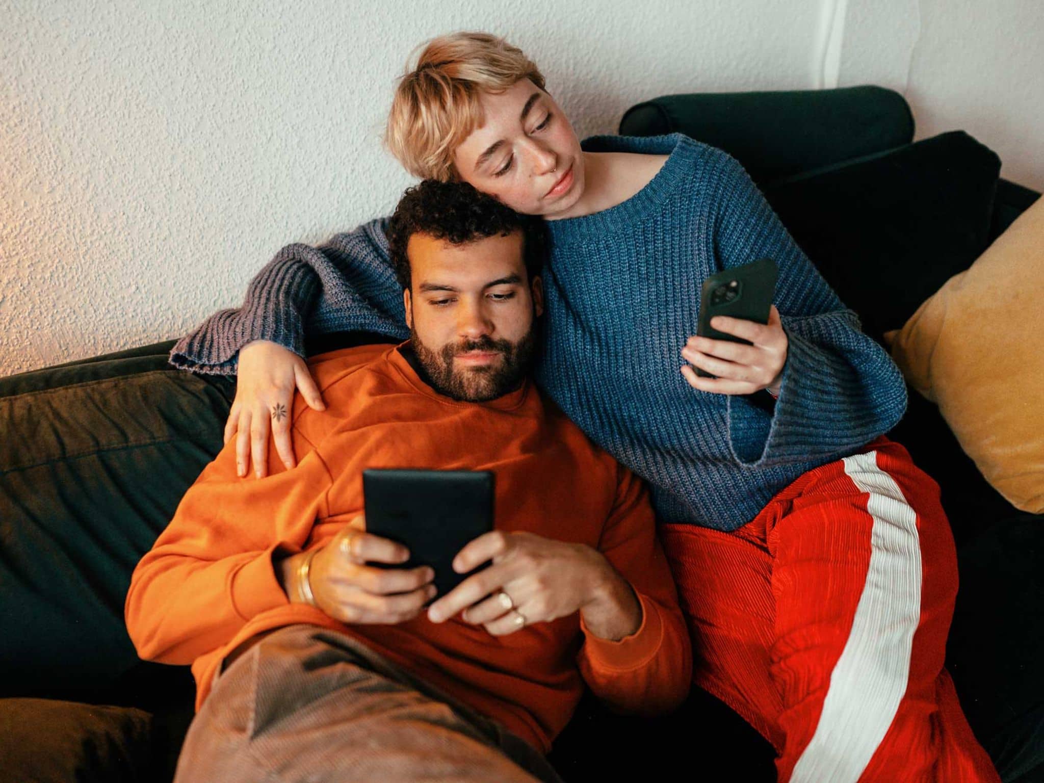 Auswirkungen von Social Media: Paar mit Handy auf der Couch